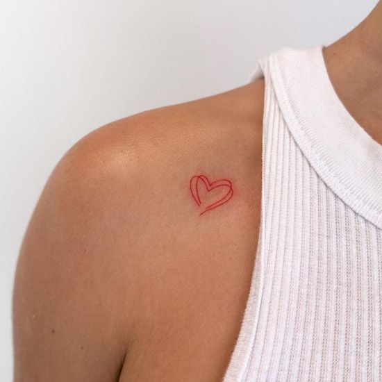 a woman with a red heart tattoo on her shoulder