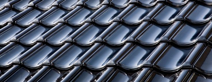 a close up view of the roof of a building with black shingles on it