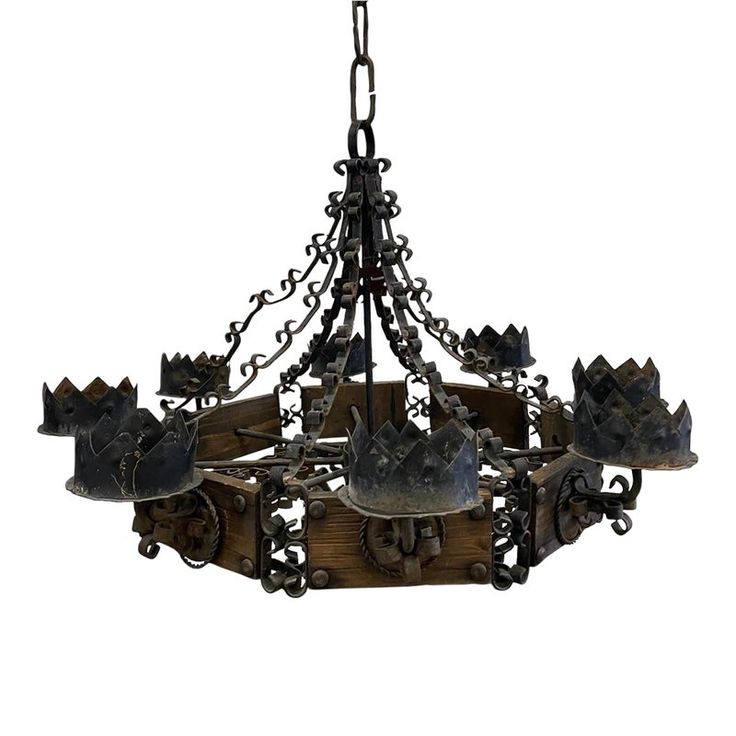 a chandelier made out of metal and wood with crowns hanging from the bottom