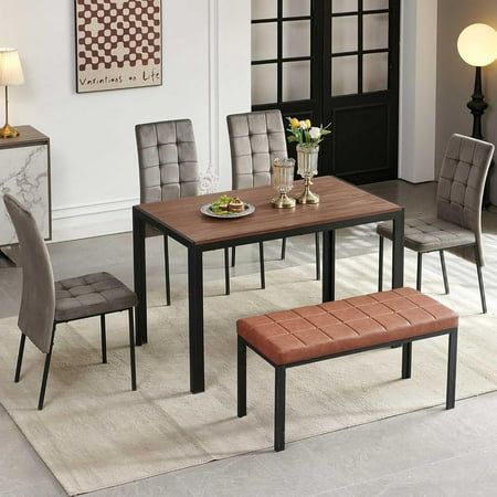 a dining room table with four chairs and a bench