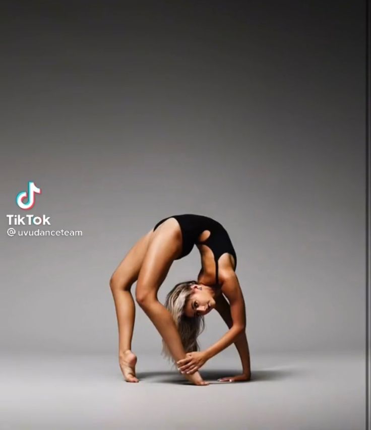 a woman in a black leotard doing a handstand