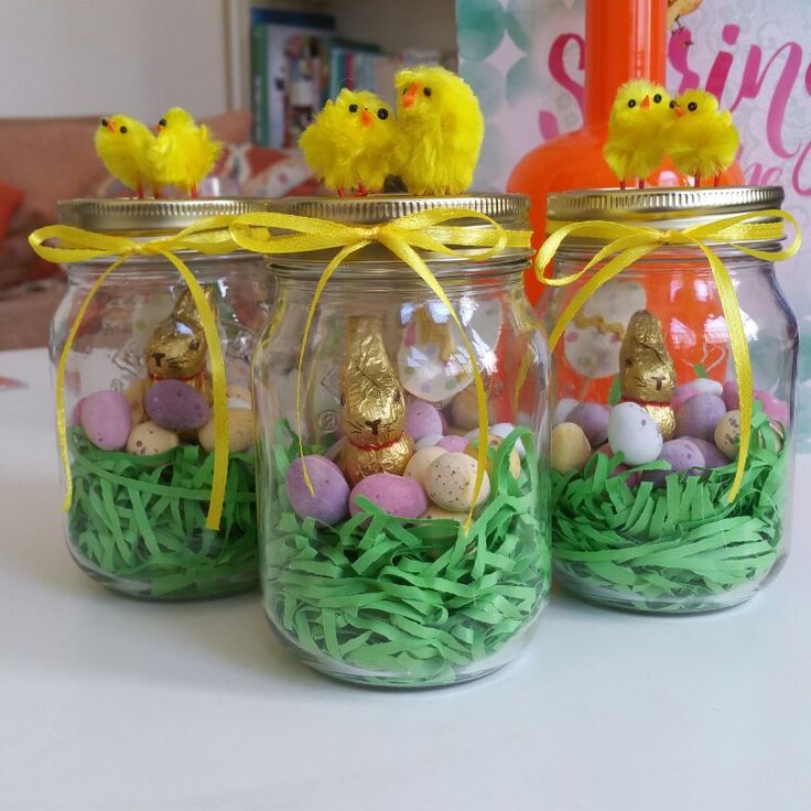 three glass jars filled with eggs and grass