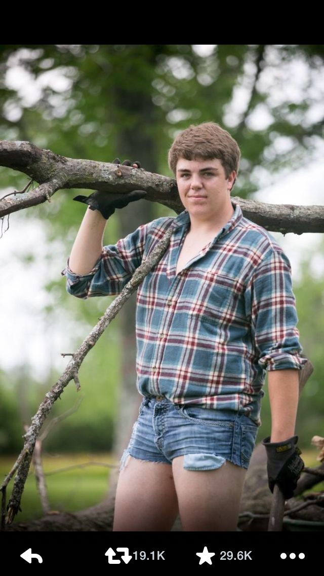 a young man standing next to a tree branch