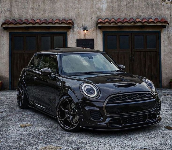 a black mini cooper parked in front of a building