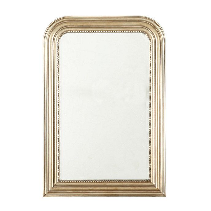 a white and gold framed mirror on a white wall with an ornate border around the edges