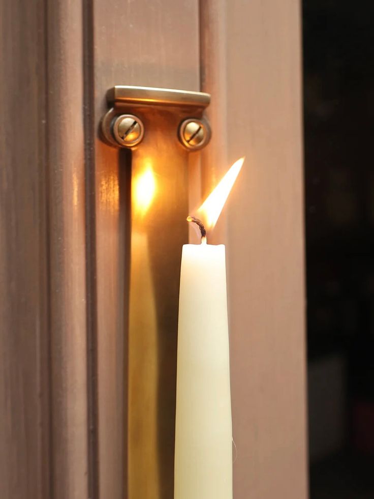 a white candle is lit in front of a door