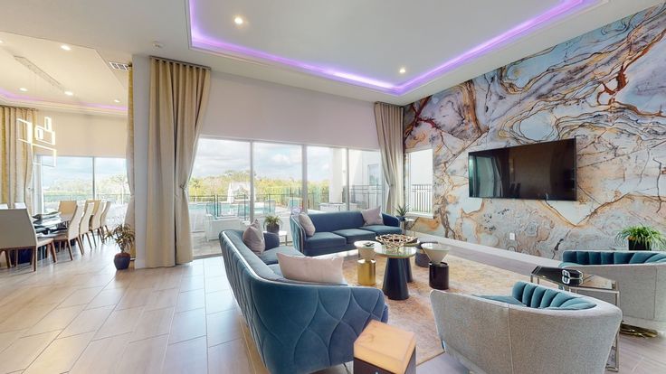 a living room filled with lots of furniture and a flat screen tv mounted to the wall