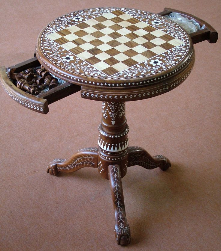 an ornately decorated table with chess board on it's top and drawer for storage