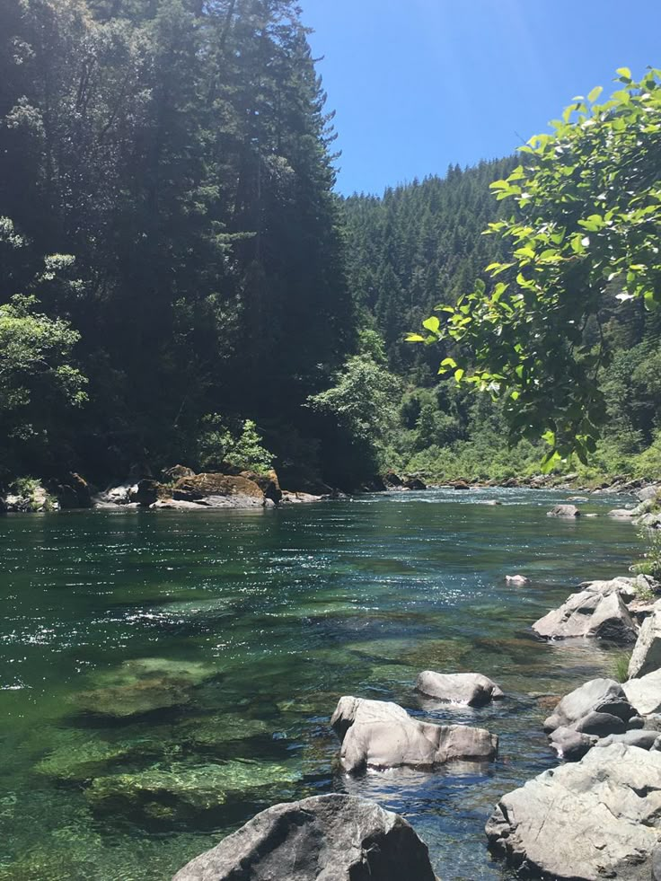 the water is crystal green and clear in this river scene with rocks on both sides