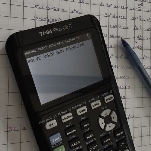 a calculator sitting on top of a piece of paper next to a pen