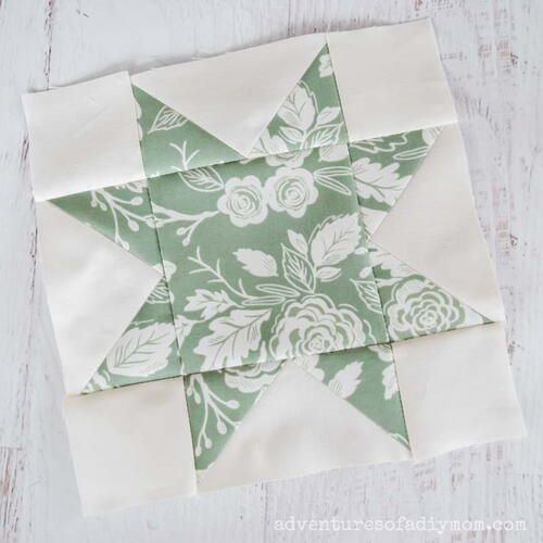 a green and white quilted star sitting on top of a wooden table