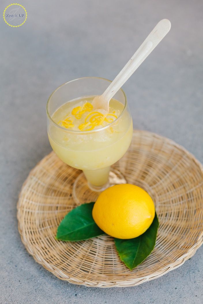 a glass filled with lemonade sitting on top of a wicker plate