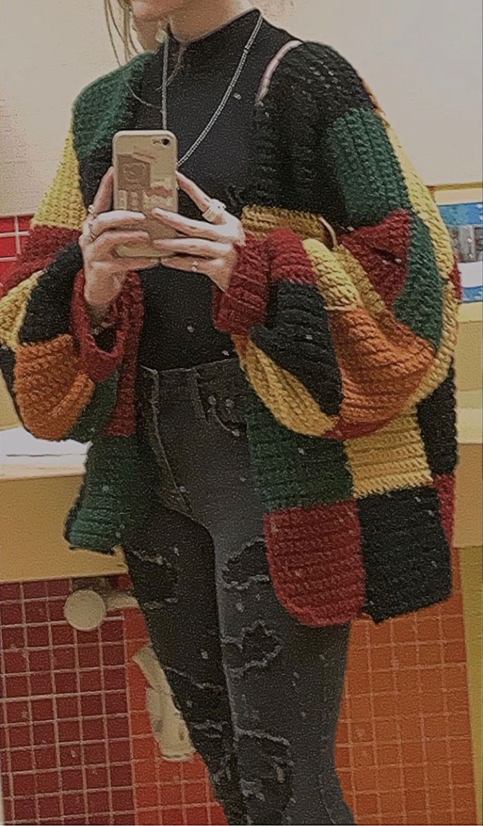 a woman is taking a selfie in the mirror with her cell phone while wearing an oversize sweater