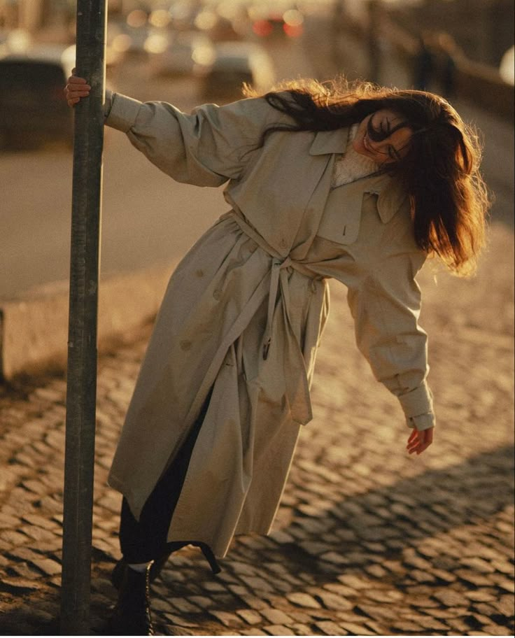 a woman leaning up against a street sign