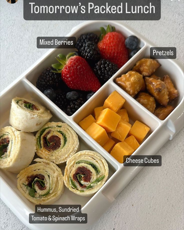 a lunch box filled with rolls, fruit and muffins next to each other