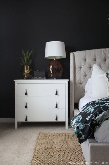 a bedroom with black walls and white furniture