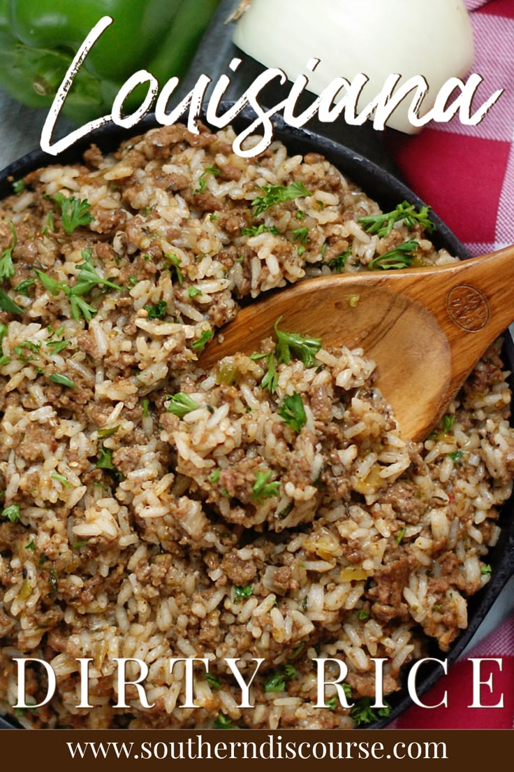 a close up of rice in a pan with a wooden spoon