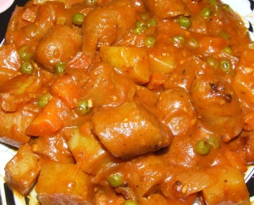 a black and white plate topped with meat covered in gravy on top of a table