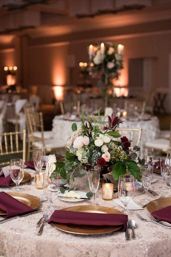 the table is set with white and red flowers, silverware, and wine glasses