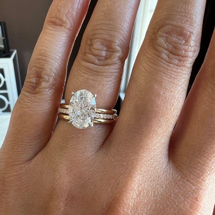 a woman's hand with a ring on it and a diamond in the middle