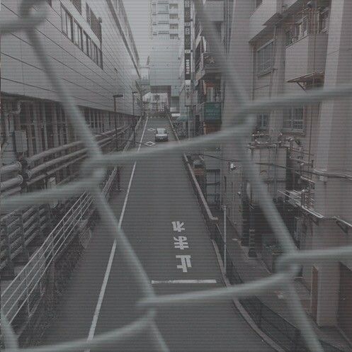 a city street with buildings and signs on the road behind a chain link fence that reads, hong kong