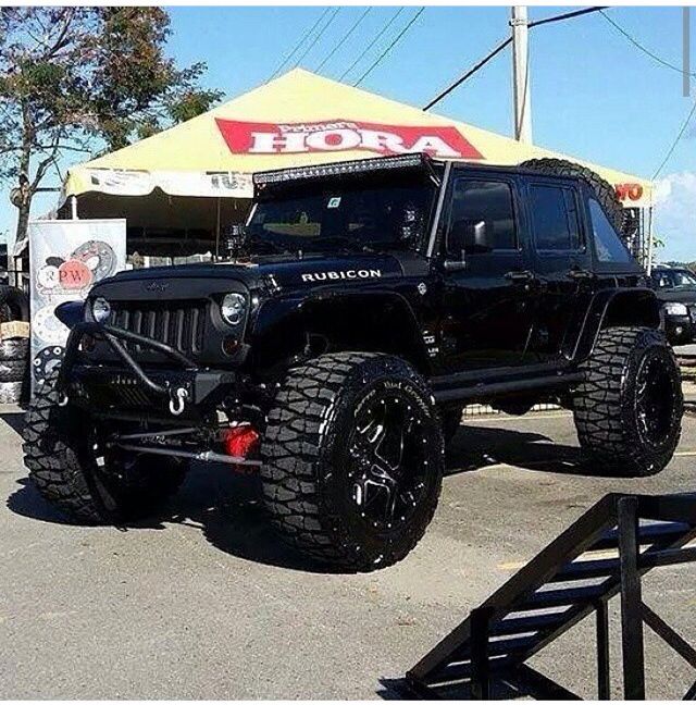 a black jeep is parked in front of a building with a sign that says hoora on it