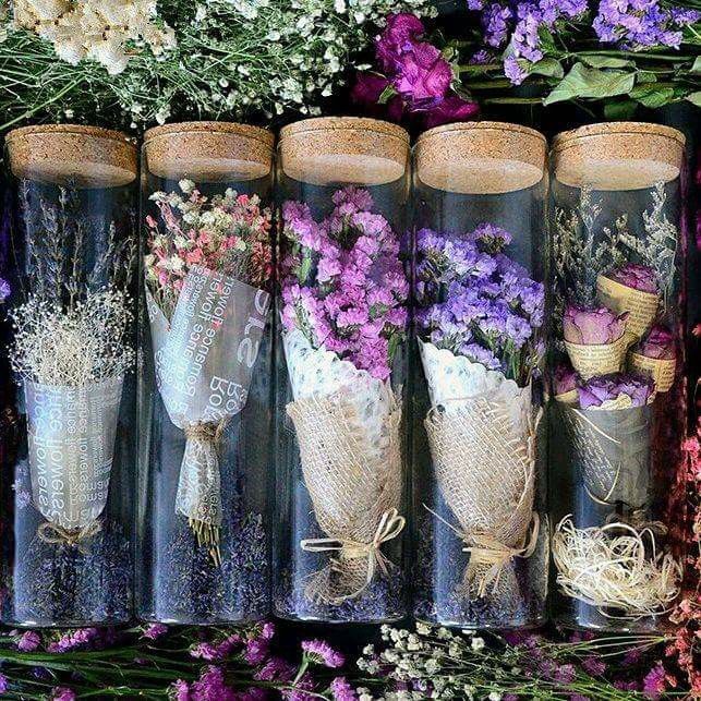 flowers in vases are lined up on the shelf next to each other and tied with twine