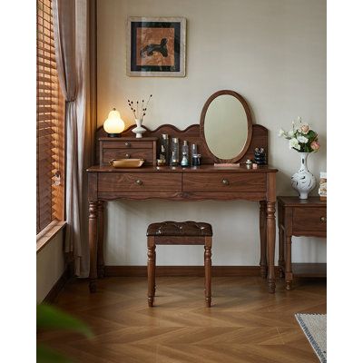 a dressing table with a mirror and stool in front of it on a hard wood floor