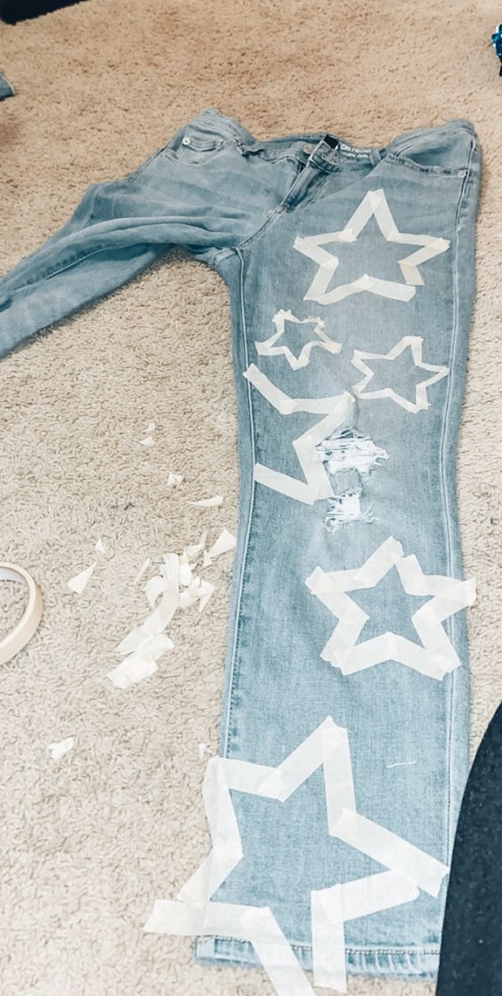 a pair of jeans that have been cut out and are laying on the floor next to someone's shoes