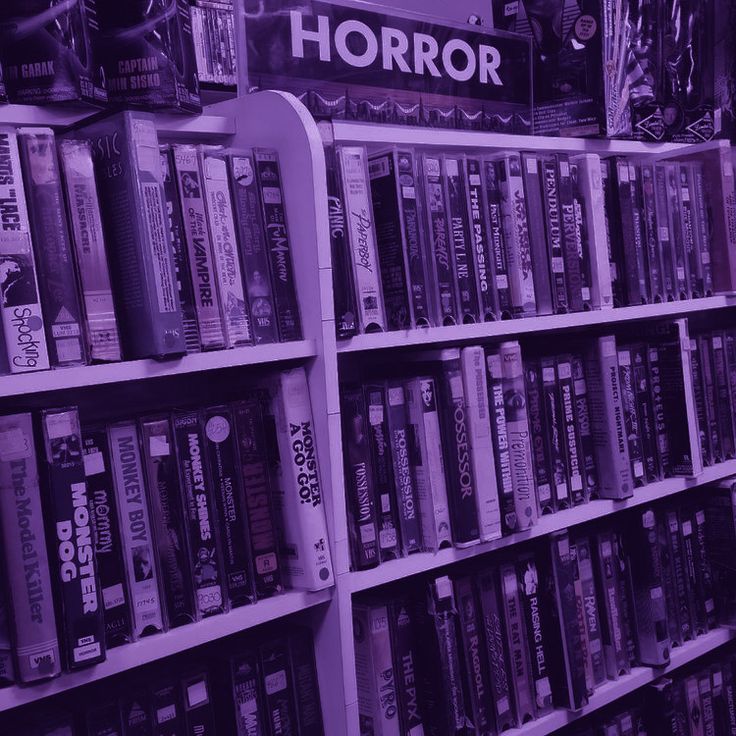 a shelf filled with lots of books in front of a sign that says horror on it