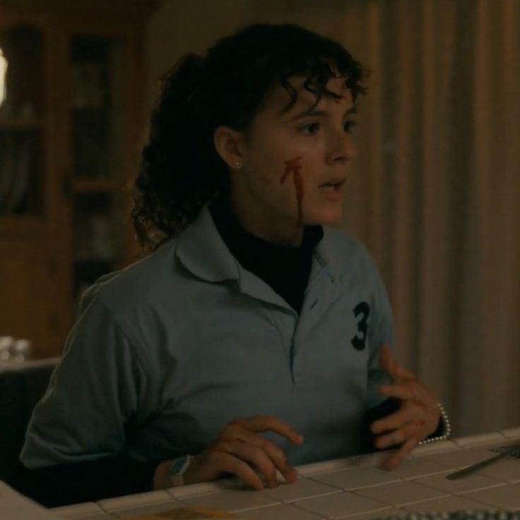 a woman sitting at a computer desk with blood on her face