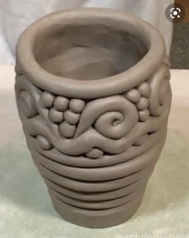 a clay vase sitting on top of a table