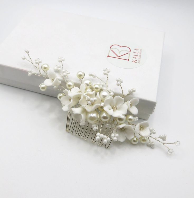 Bridal pearl and ceramic porcelain flower twisted wire hair comb. Wedding hairpiece floral hairdo styling decorative hairpin comb.Lightweight and elegant, this beautiful wedding theme floral hair comb integrates seamlessly into any hairdo. You can wear it with a high or low bun, or simply place it on a side for more casual, but chic bridal look. Hand-wired branches can be easily bent according to your style or desire. Delicate ceramic flowerheads, beads and pearls attached to the wire create a v Wedding Floral Headpiece, Fairy Creatures, Floral Headpiece Wedding, Pearl Bridesmaid Jewelry, Floral Hair Comb, Wedding Hairpiece, Beach Jewelry Boho, Bridal Jewelry Necklace, Floral Hair Combs