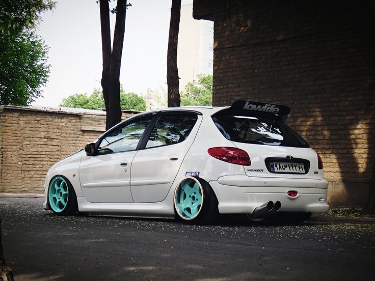 a white car parked next to a brick building