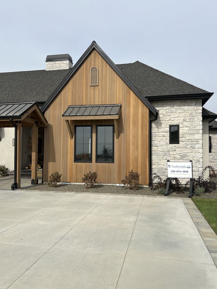 a house with a sign in front of it that says, the building is made out of wood