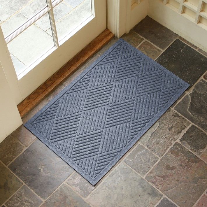 a blue door mat sitting on top of a floor next to an open door with a window