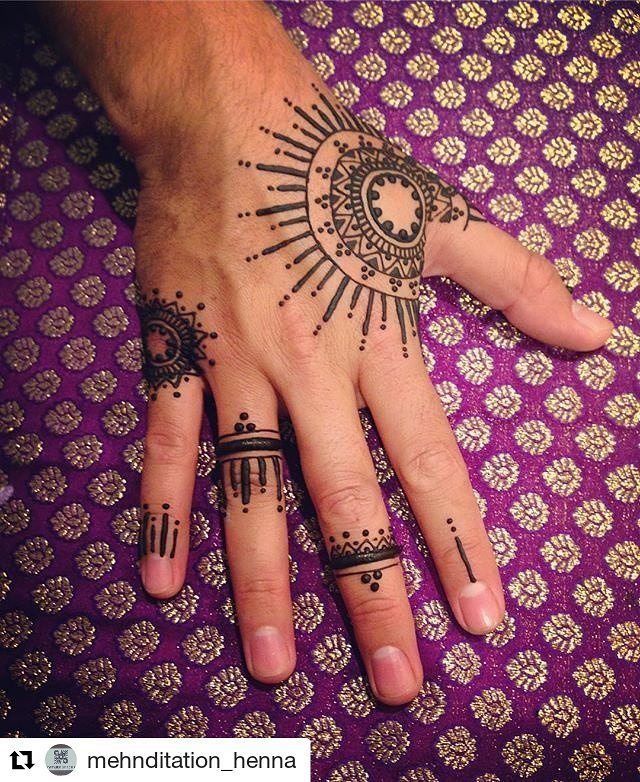 a person's hand with henna tattoos on it and the sun in the middle