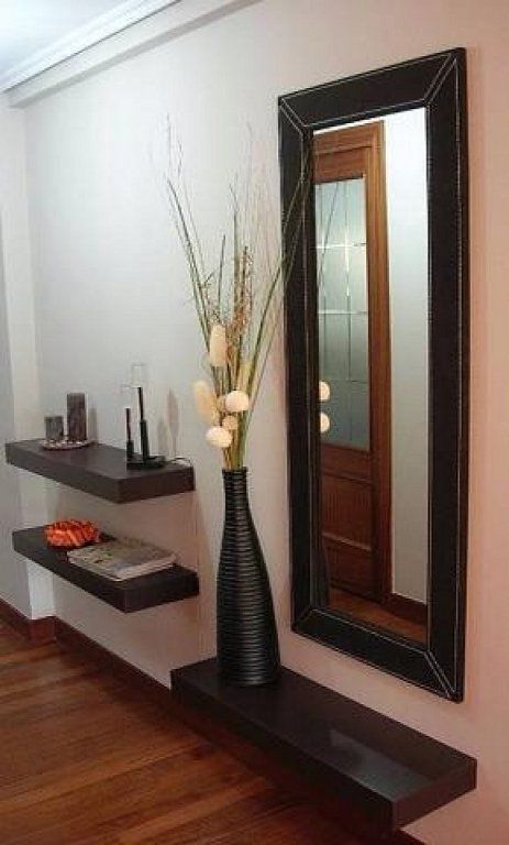 a vase with flowers is sitting on a shelf in front of a mirror and shelves