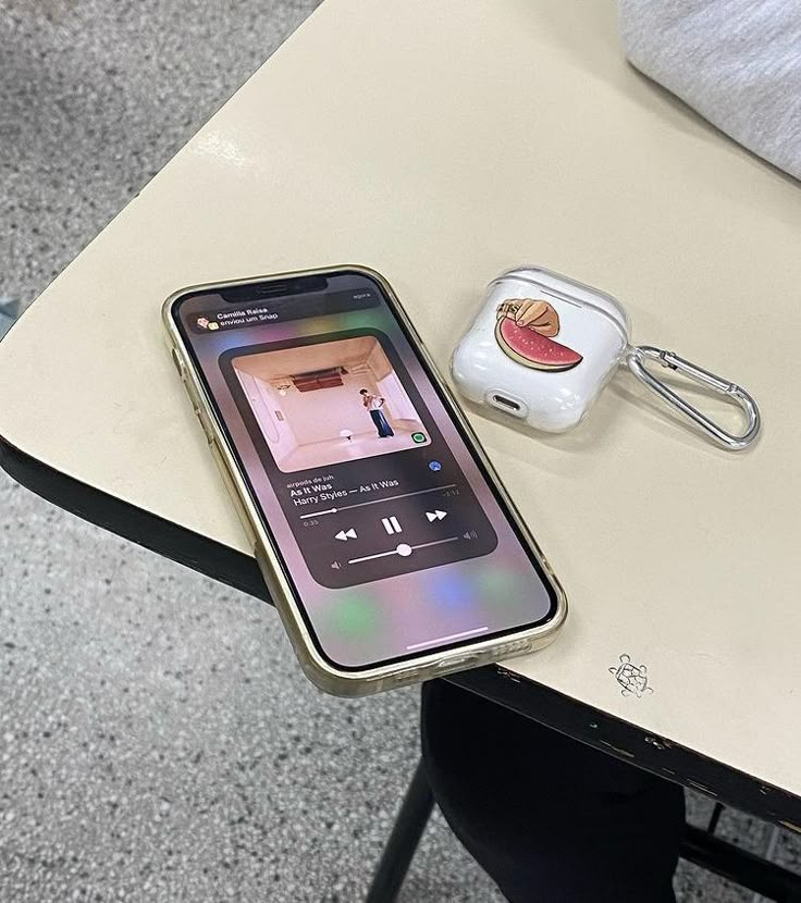 an apple airpods sitting on top of a table next to a cell phone and ear buds