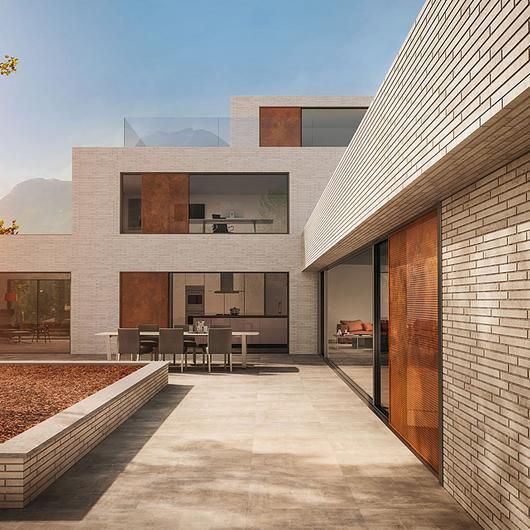 an empty courtyard with tables and chairs in the background