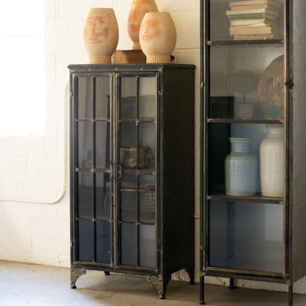 two vases sitting on top of a glass cabinet in front of a white wall