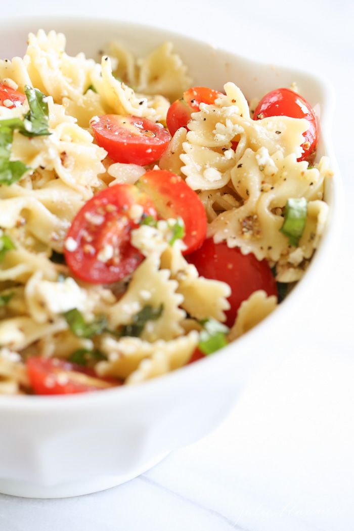 a white bowl filled with pasta and vegetables