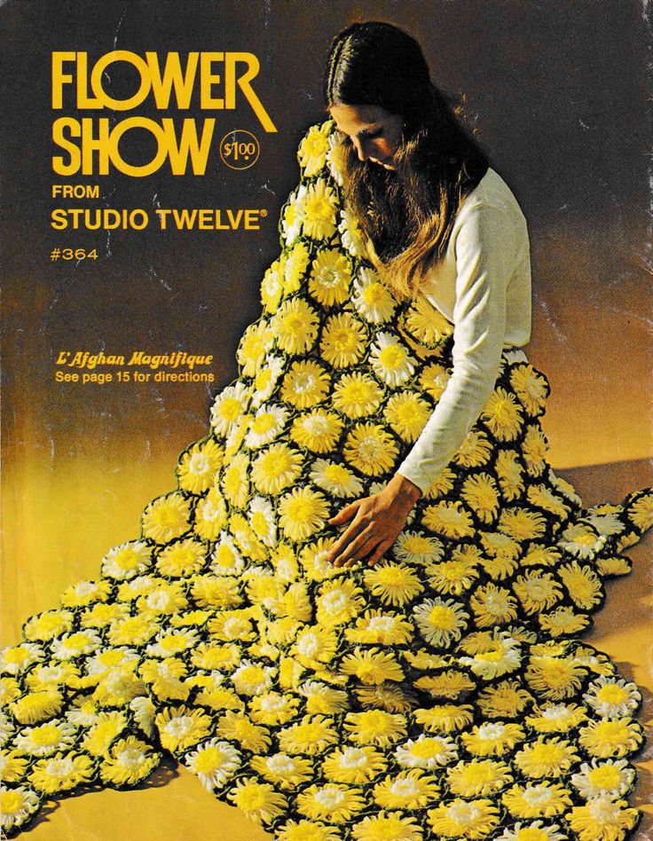 a woman sitting on the ground covered in yellow flowers