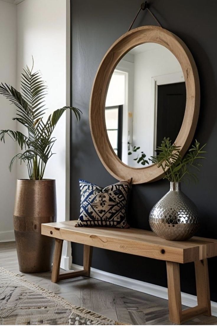 a wooden bench sitting next to a mirror and potted plant on top of it