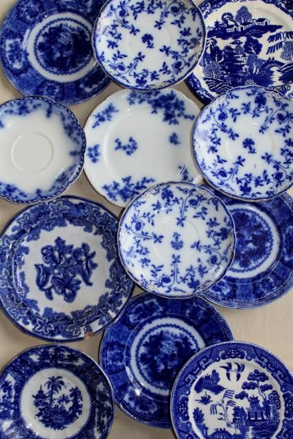 many blue and white plates are arranged together