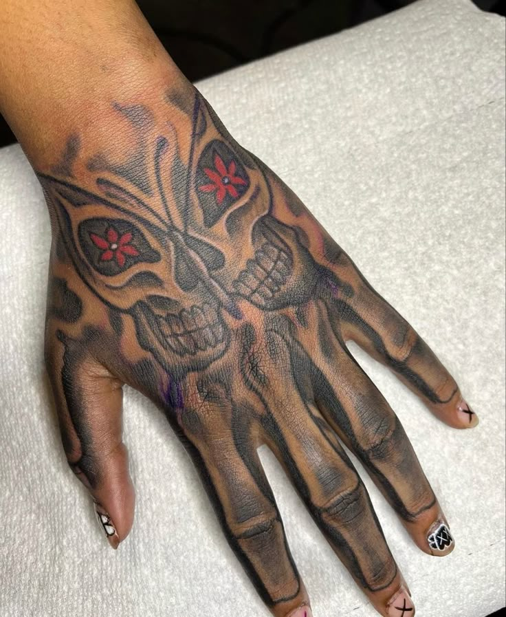 a woman's hand with a skull and cross tattoo on the middle of it