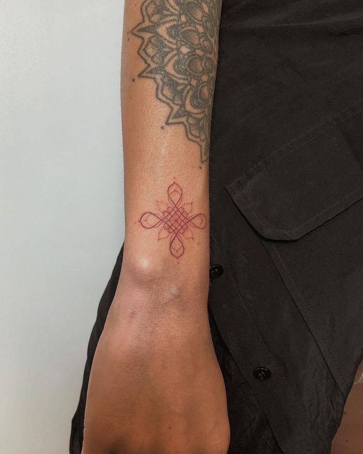 a woman's arm with a tattoo on it and a cross in the middle