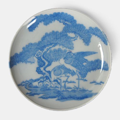 a blue and white plate with an image of a bird in flight on the side