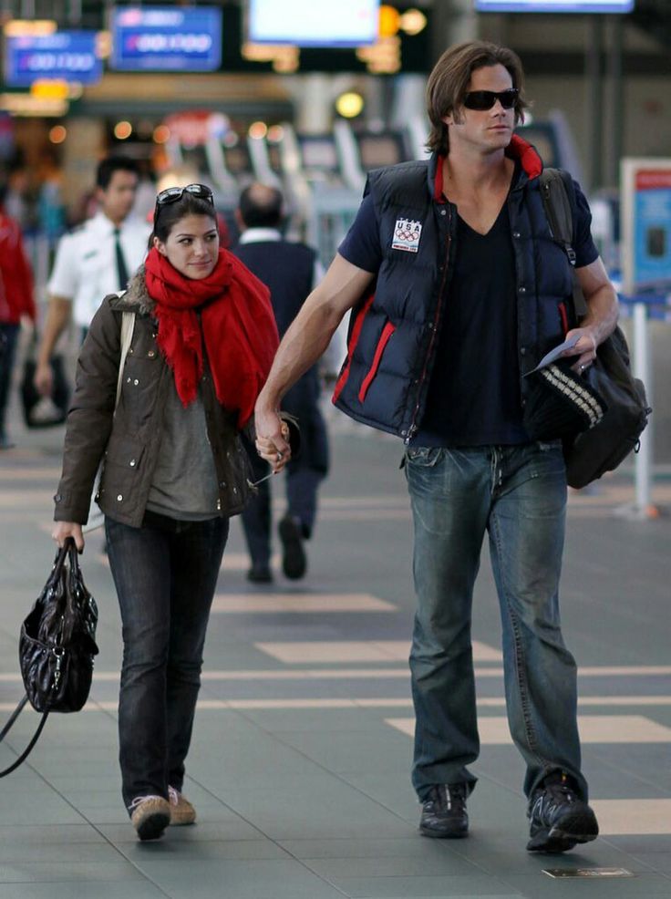 a man and woman walking down the street holding hands