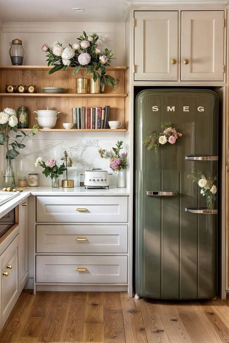 an old refrigerator is in the middle of a kitchen with white cabinets and wood floors